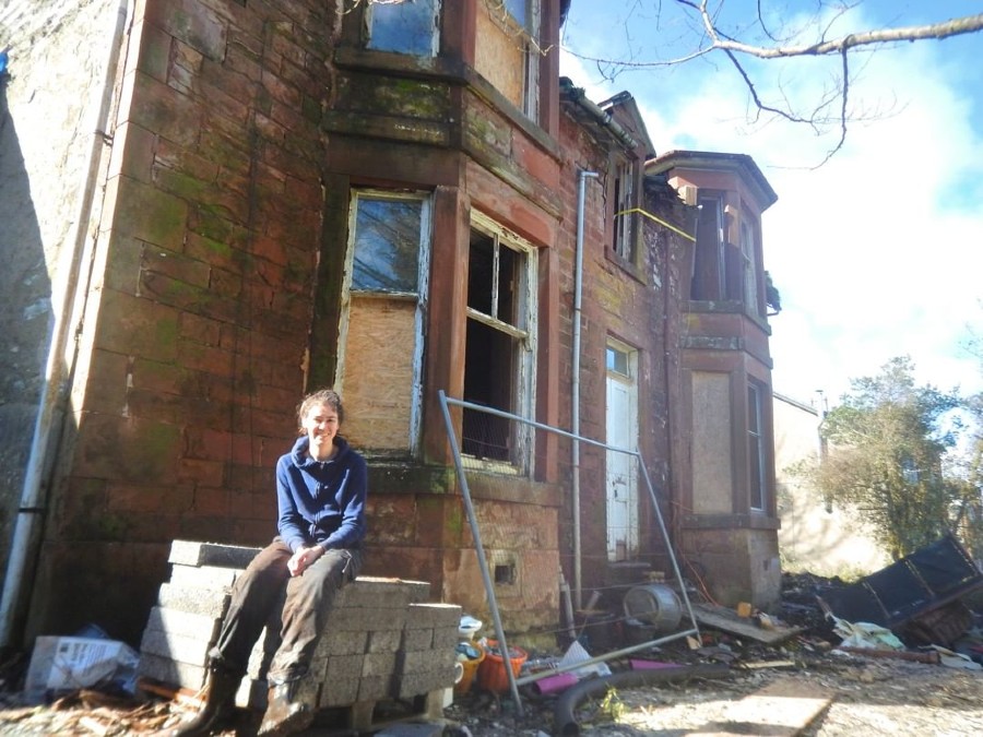 Claire outside the mansion in its original derelict state.