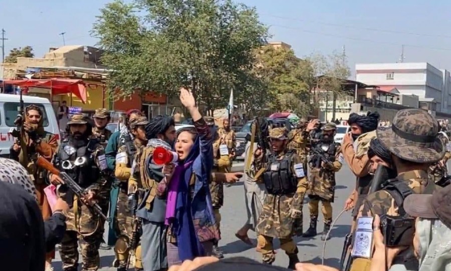 Afghan women protesting the Taliban reign while soldiers follow them