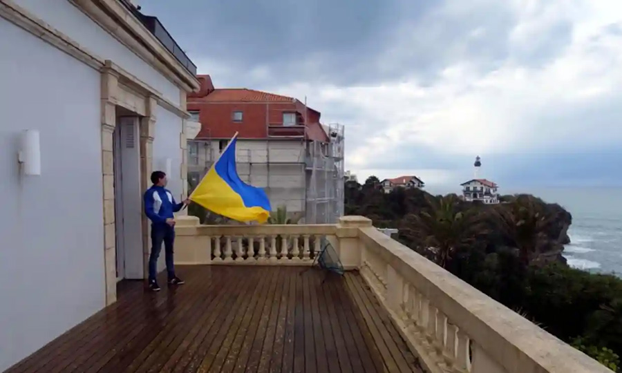 One of the activists on an upper-floor balcony of the Alta Mira villa in Biarritz. Image courtesy: Youtube.