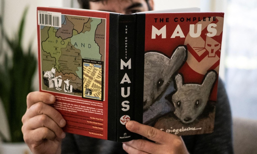 A person holding the graphic novel 'Maus' by Art Spiegelman - a frequently banned book. (Photo: AFP VIA GETTY IMAGES)