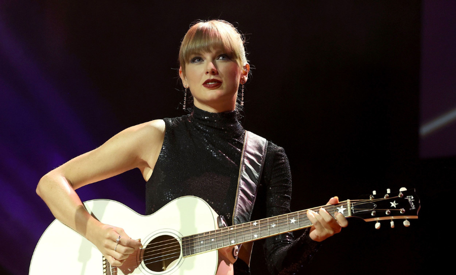 Taylor Swift performing with guitar on stage