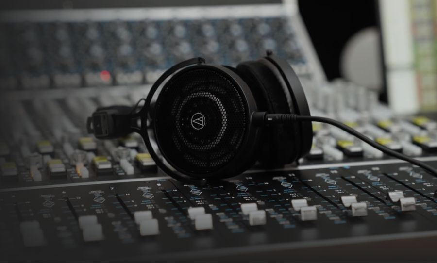 headphones on. a mixing desk - happy mag